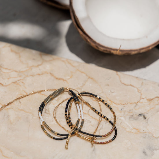 Gold Beaded Necklace and Bracelet Set handmade by Village Thrive using natural materials.